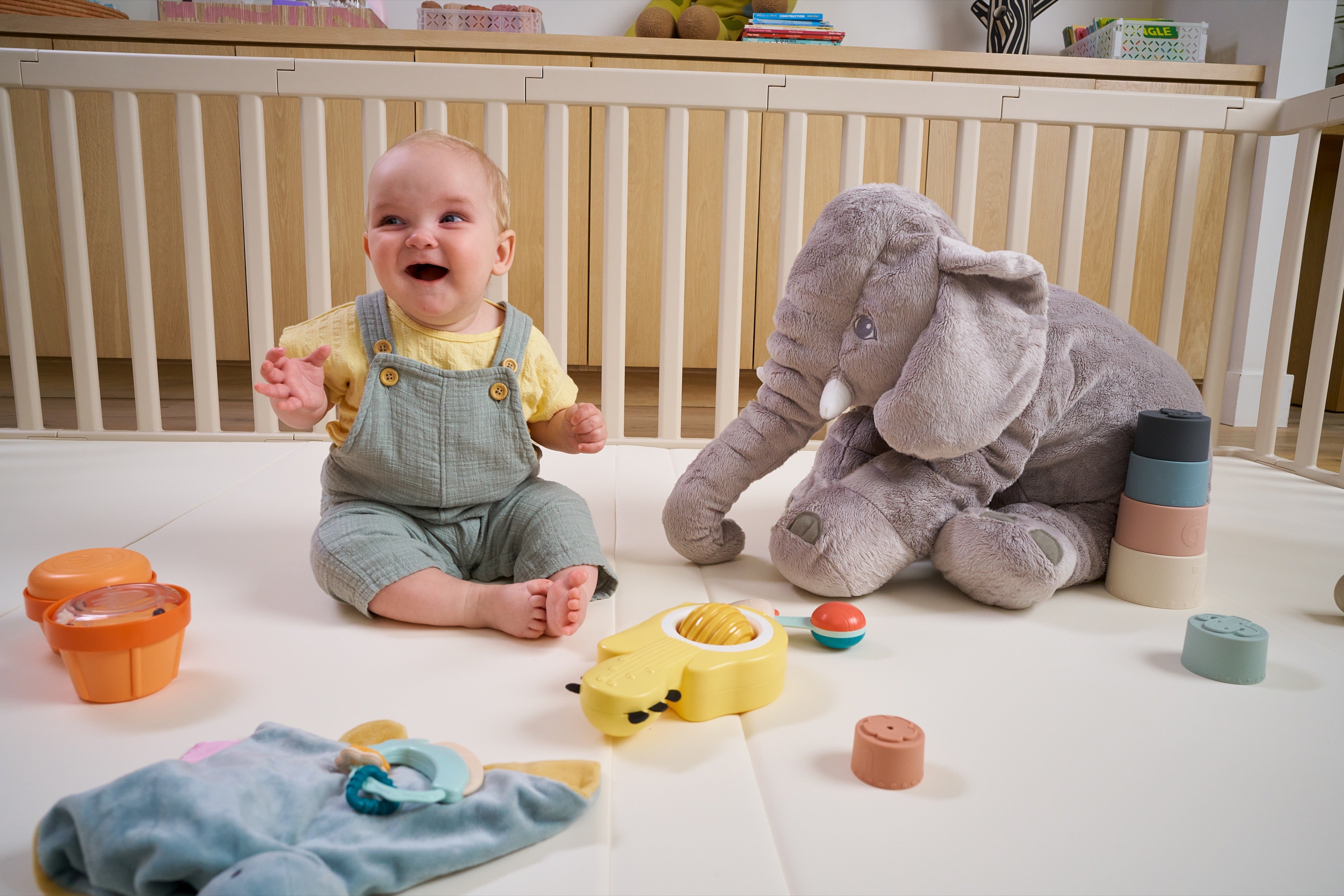 Baby practicing independent play inside a safe play mat and playpen baby play area