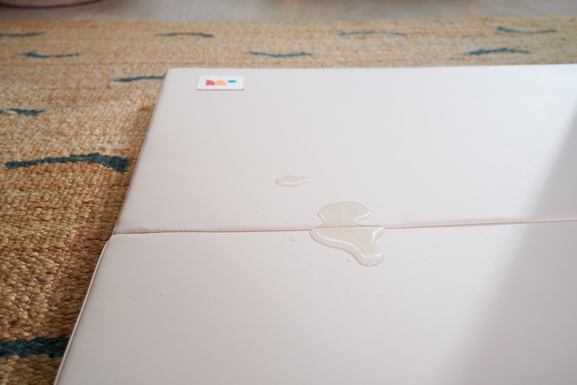 Close-up of water-resistant non-toxic cushioned baby play mat surface with liquid spill
