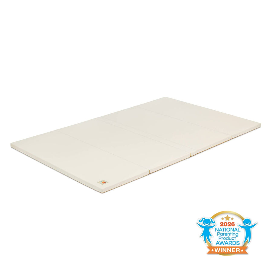 Cream non-toxic cushioned baby play mat with wipe-clean vegan leather, laid flat on floor with National Parenting Product Awards Seal