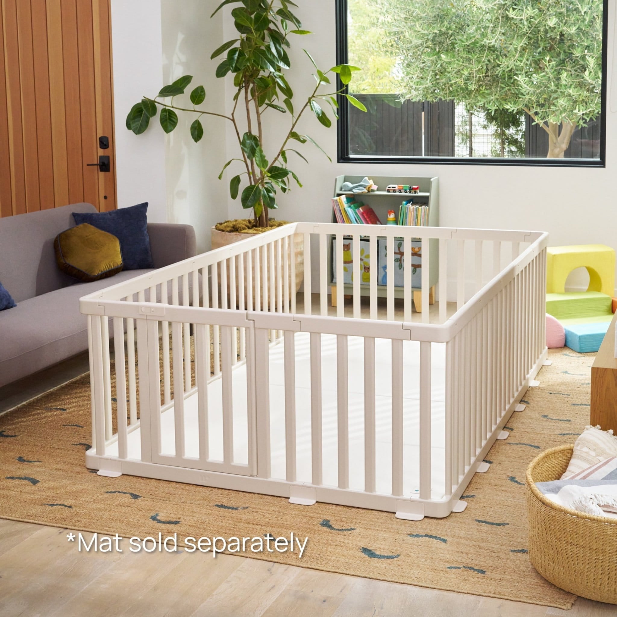 Minimalist white baby playpen with cushioned non-toxic play mat styled in a modern living room