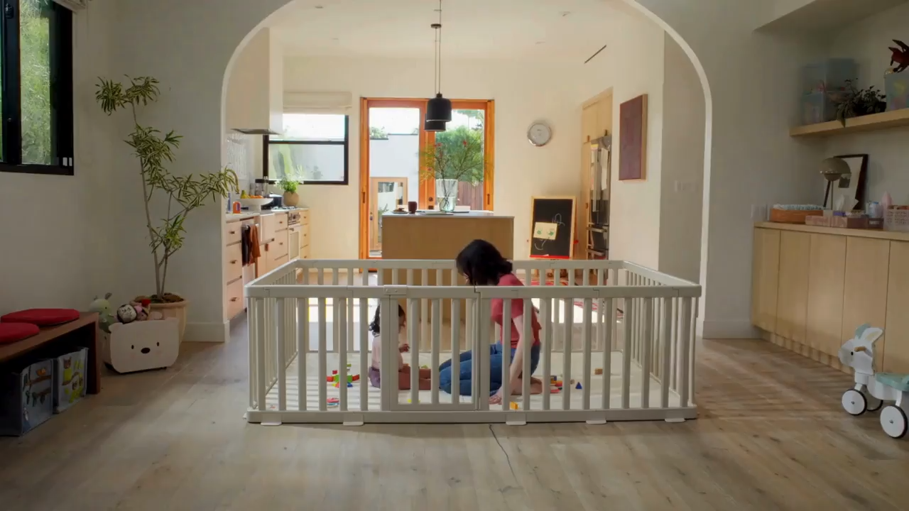 Baby playing safely inside a premium non-toxic playpen and cushioned play mat set in a bright modern home