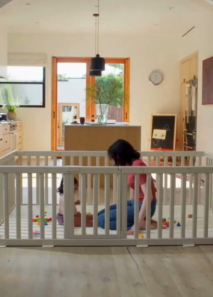 Baby playing safely inside a premium non-toxic playpen and cushioned play mat set in a bright modern home
