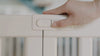 Use the door handle to open and securely close the playpen