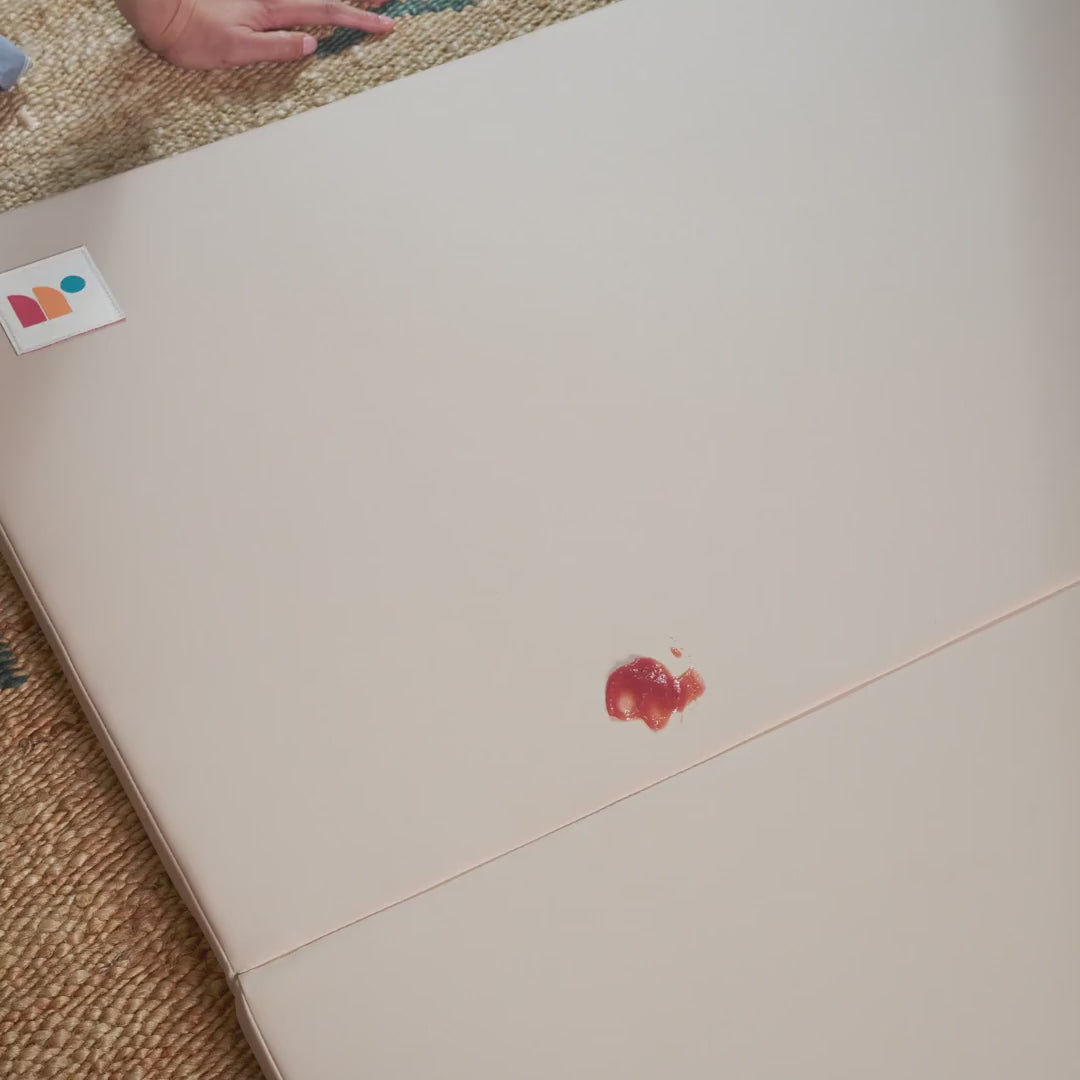 GIF showing stain wiped clean from safe, non-toxic, neutral baby play mat vegan leather surface
